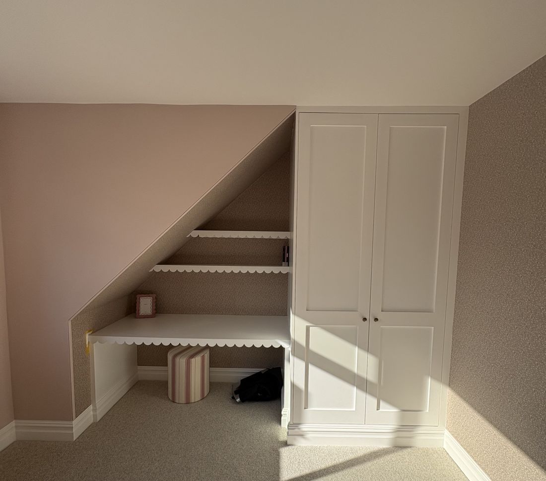 White shaker fitted wardrobe with a built-in desk under the eaves