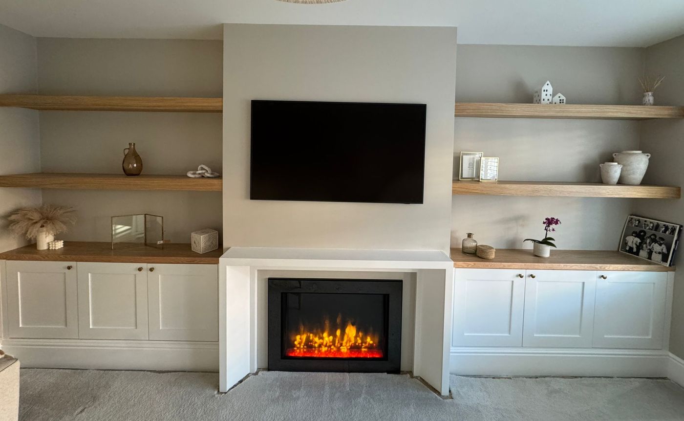 Media wall with inset fire, shaker alcove cupboards and floating oak shelves